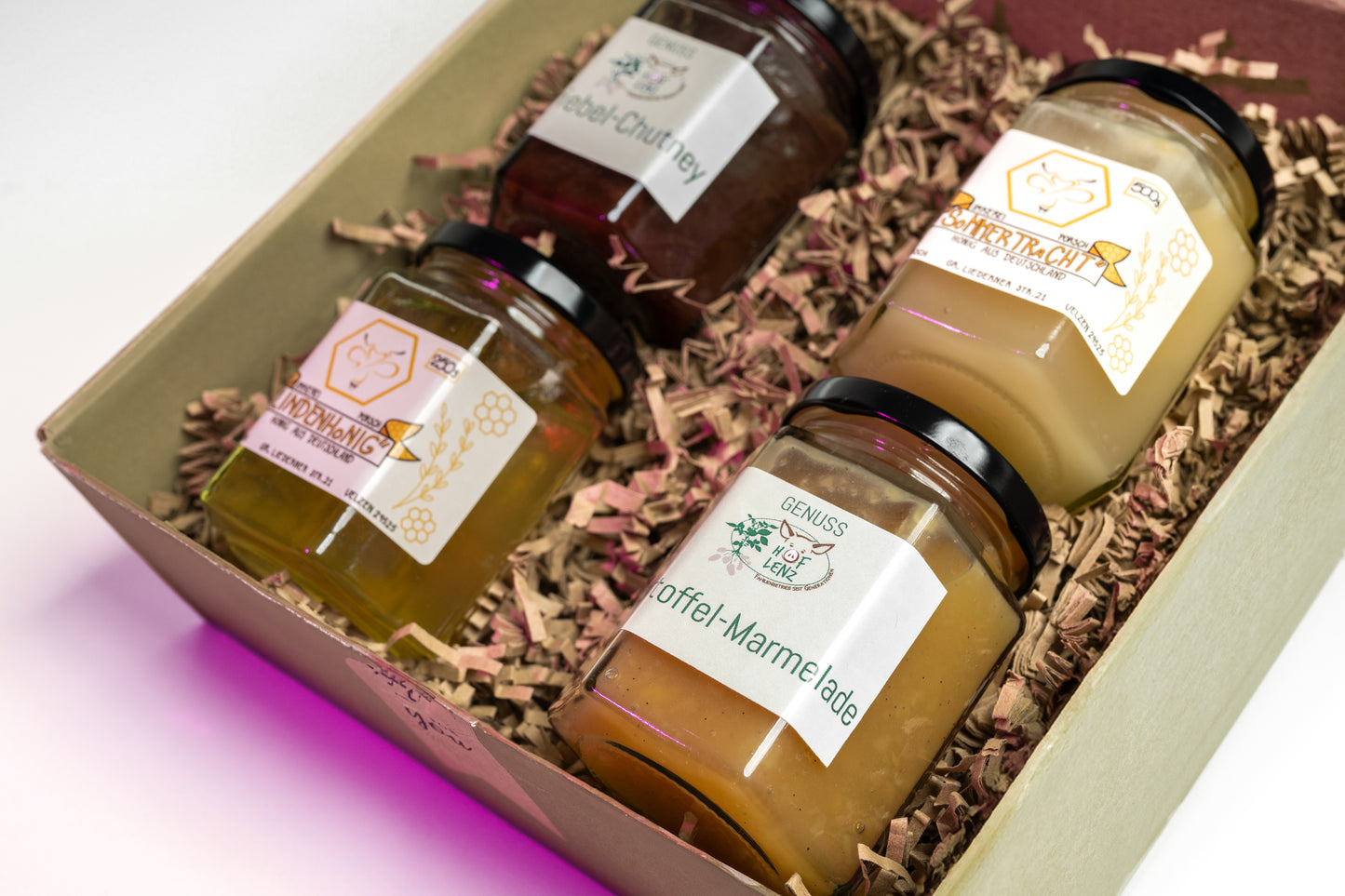 Geschenkbox vom Hof Lenz mit Lindenhonig, Sommertracht, Kartoffel-Marmelade und Zwiebel-Chutney auf Holzwolle