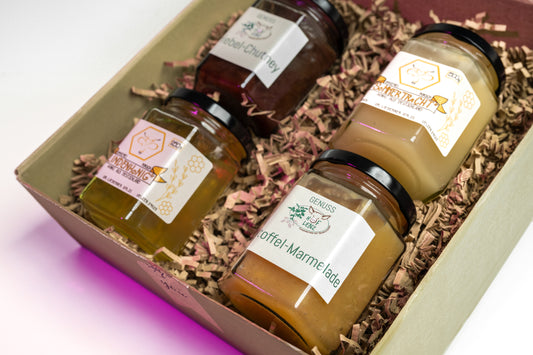 Geschenkbox vom Hof Lenz mit Lindenhonig, Sommertracht, Kartoffel-Marmelade und Zwiebel-Chutney auf Holzwolle